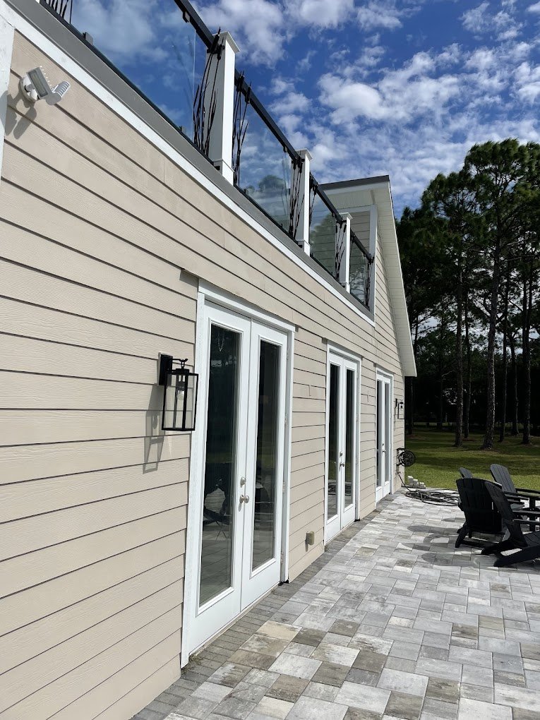 Clean siding and patio area after professional house washing in Brevard and Volusia County by Suncoast Softwash.