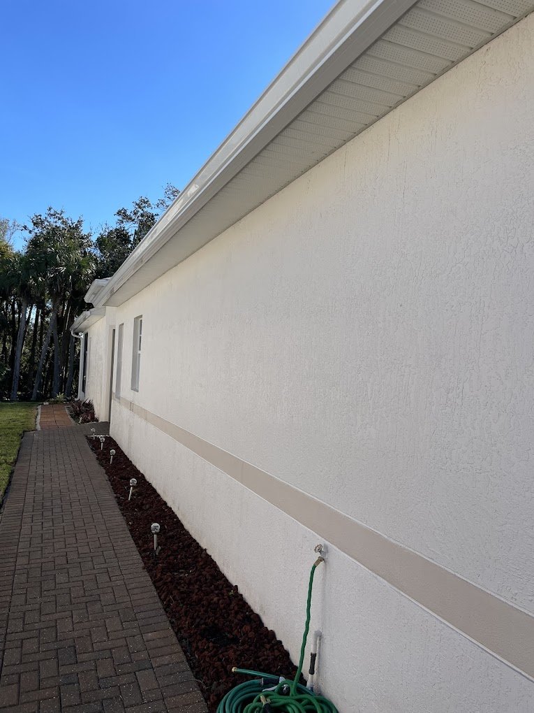 Bright white exterior wall after professional house washing in Brevard and Volusia County by Suncoast Softwash.