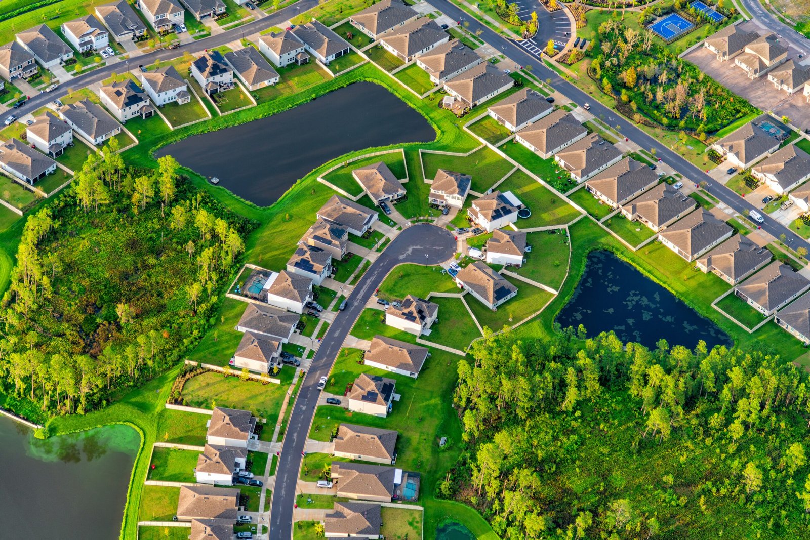 does house washing increase home value aerial view of a clean Florida HOA community with maintained homes, manicured lawns, retention ponds, and strong curb appeal in a suburban neighborhood